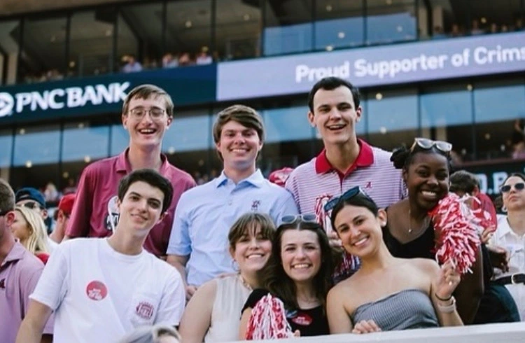 nick poses with a group of friends inside bryant-denny stadium