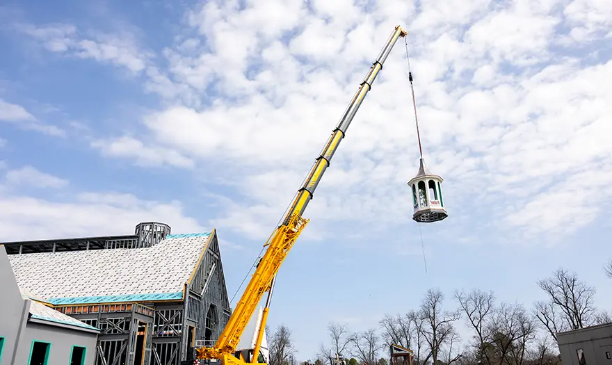 A crane lifts the cupola above UA's newly constructed Well-Being Hub.