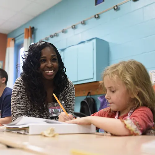 A member of Al's Pals mentors a young student.