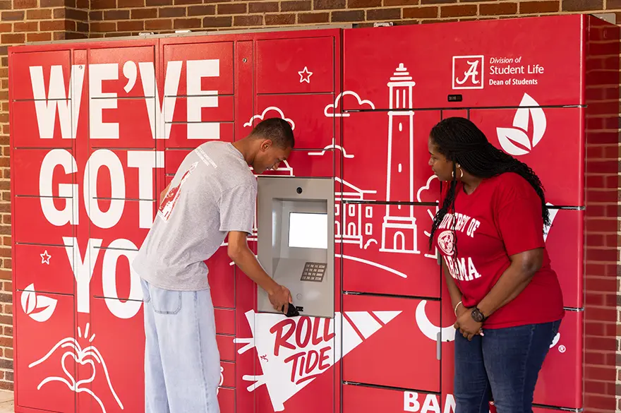 Kristen Dubose instructs a student on how to use the BamaCares food lockers.