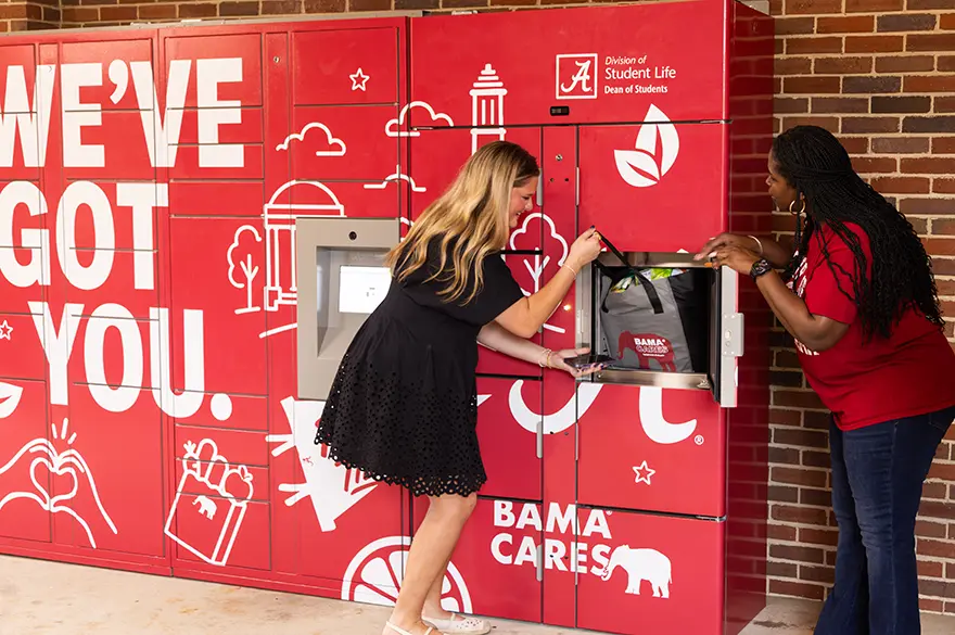 Kristen Dubose intructs Bella Fiaschetti on how to receive an item from the BamaCares food lockers.